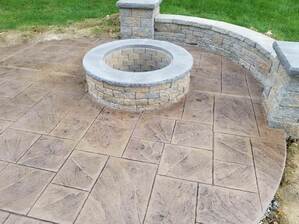 A stamped concrete patio with a fireplace 